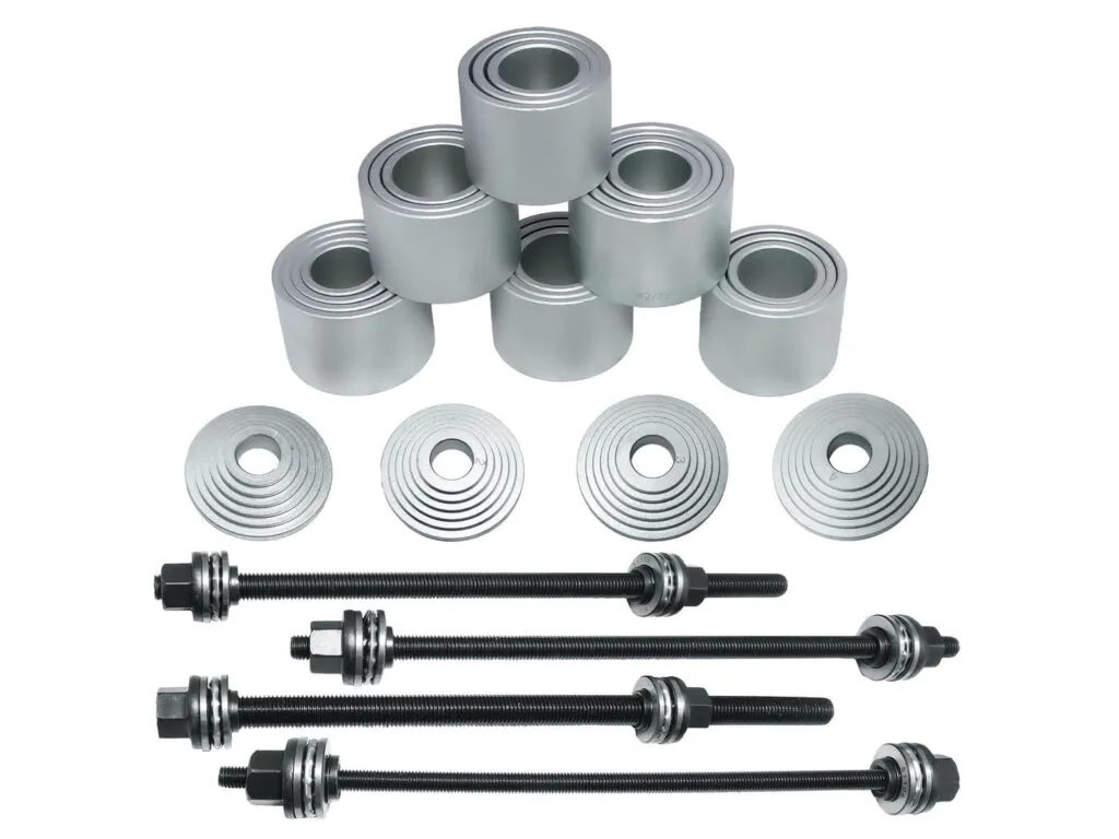Bộ dụng cụ đóng vòng bi TMFT: Các ống ép, đĩa đệm và bốn ty ren bày rời trên nền trắng