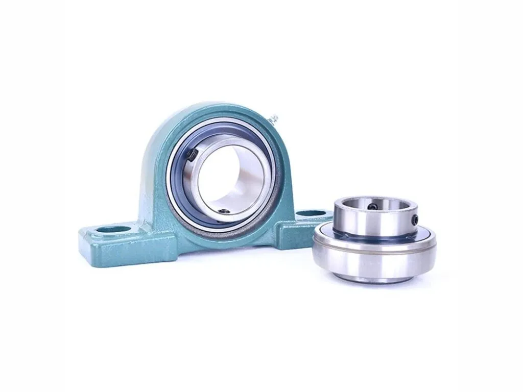 Gối đỡ UCP: Gối đỡ UCP thân xanh đặt cạnh vòng bi bọc rời