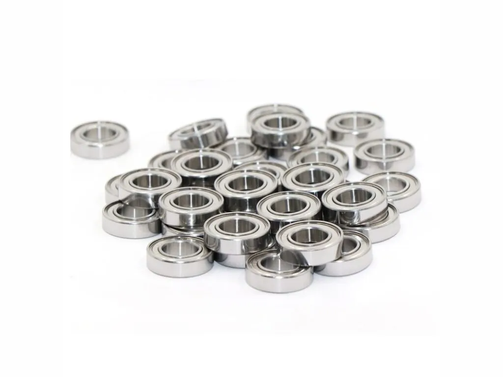 Vòng bi 608: Nhiều vòng bi mini nắp thép inox rải thành đống trên mặt trắng